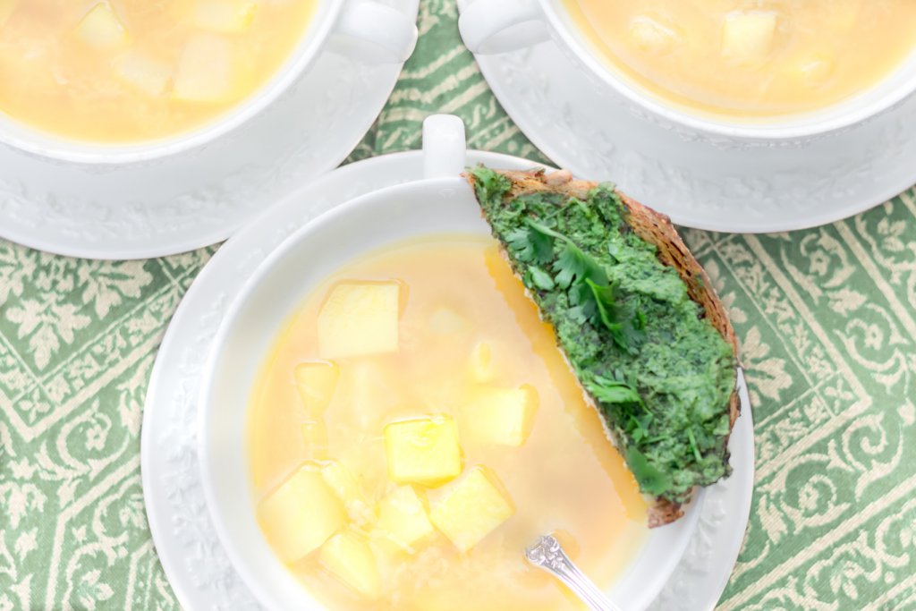 Three white Wedgwood bowls of oil-free vegan Fresh Springtime Garlic Soup with a parsley & cilantro pesto toast