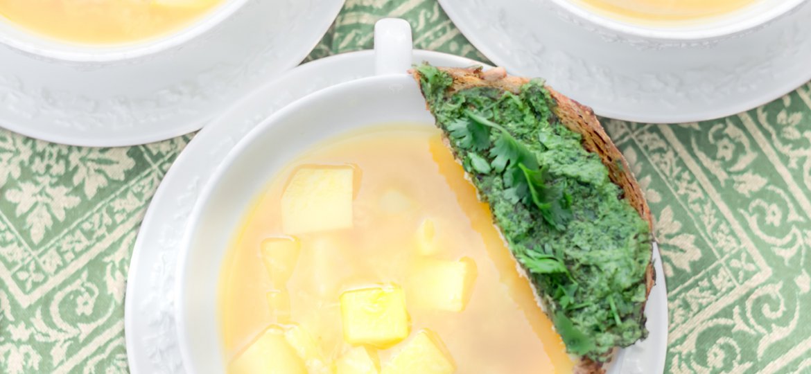 Three white Wedgwood bowls of oil-free vegan Fresh Springtime Garlic Soup with a parsley & cilantro pesto toast