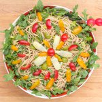 Overhead view of Oil-free Vegan Castelvetrano Olive, Tomato & Noodle Salad ready in a large serving bowl on a table.