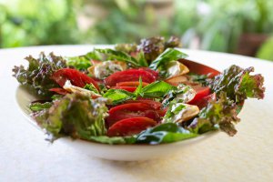 Heirloom Tomato & Basil Salad on an oval platter.