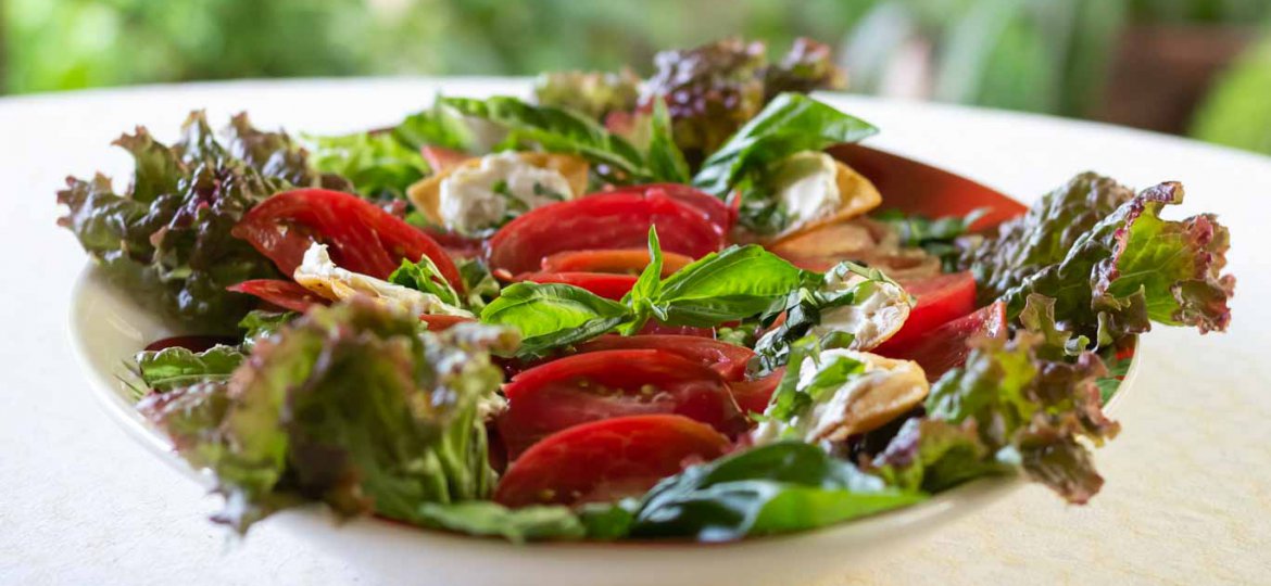 Heirloom Tomato & Basil Salad on an oval platter.