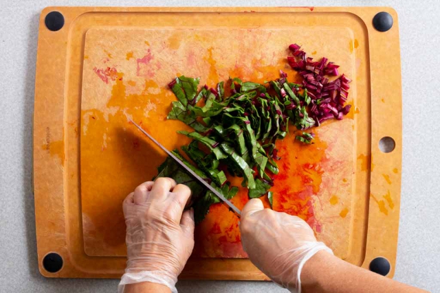 Slicing beet stalks and greens on a cutting board