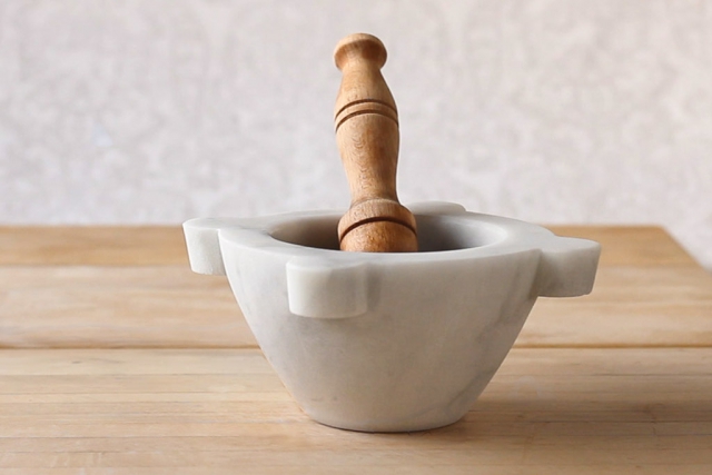 Ready to use marble mortar and wood pestle on a cutting board