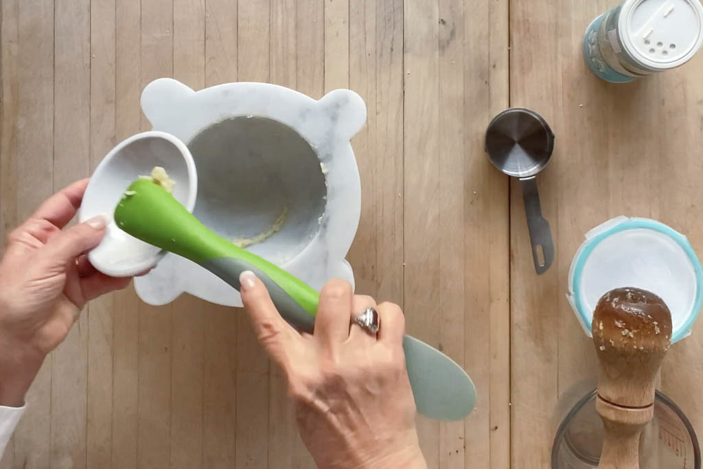 Removing garlic paste with a flexible spatula.